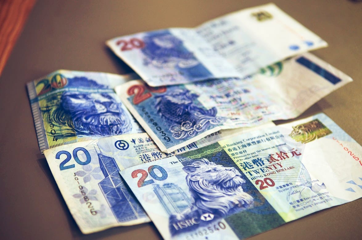 Cédulas de dólar de Hong Kong em uma mesa, ilustrando custos de viagem em Hong Kong