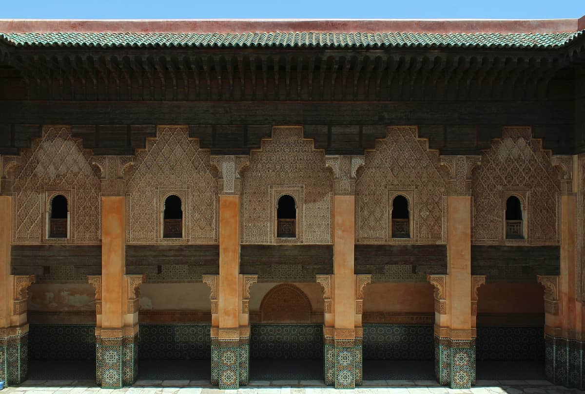 วิวด้านหน้าลานภายในอันวิจิตรของมาดราซา Ben Youssef ในเมืองมาร์ราเกช แสดงให้เห็นลวดลายกระเบื้องเรขาคณิตและงานปูนปั้นแกะสลักอันละเอียดงดงาม