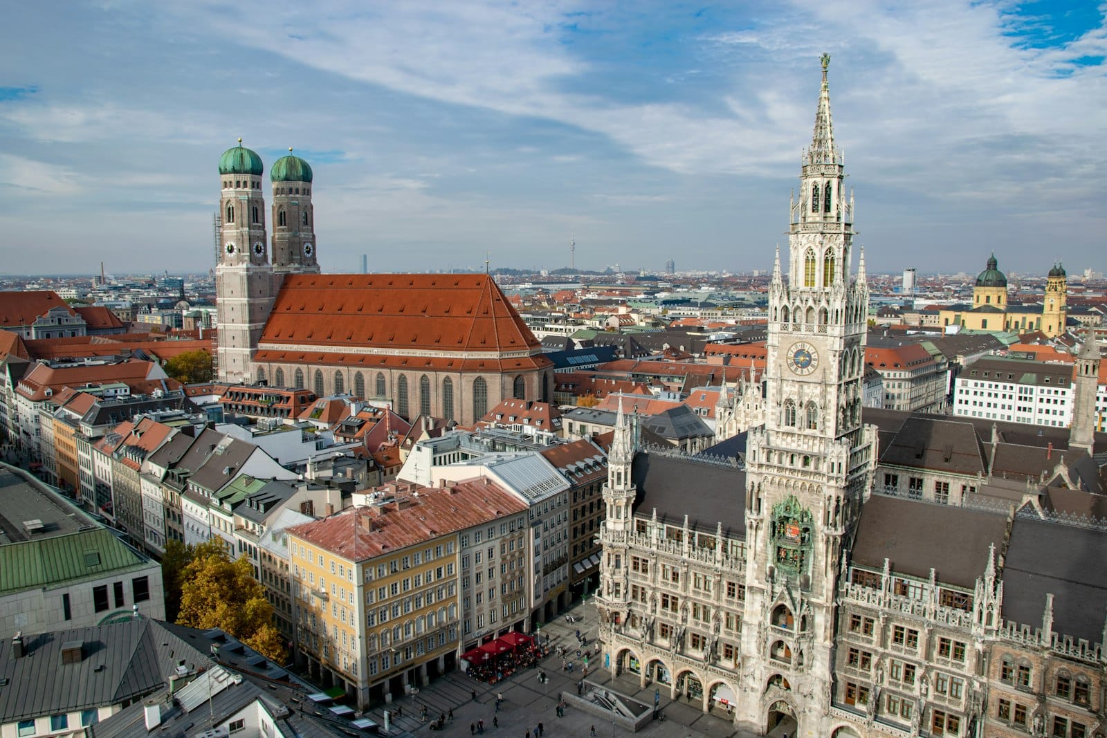 ภาพถ่ายมุมสูงของจัตุรัส Marienplatz ใจกลางเมืองมิวนิก เห็น Neues Rathaus, Frauenkirche และวิวเมืองโดยรอบภายใต้ท้องฟ้าสีครามสดใส