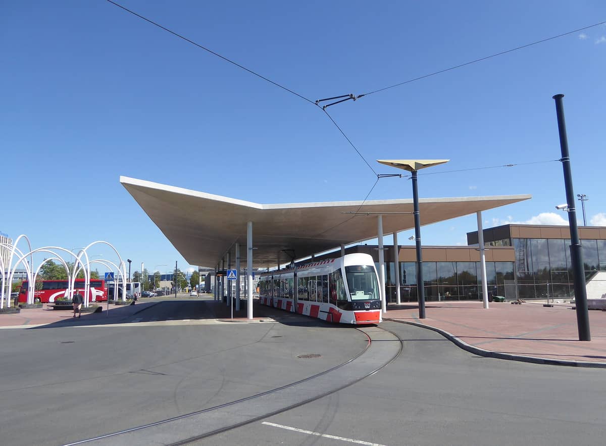 Tranvía moderno en la entrada principal del Aeropuerto de Tallin Lennart Meri en un día despejado, mostrando la conexión directa con el transporte público.