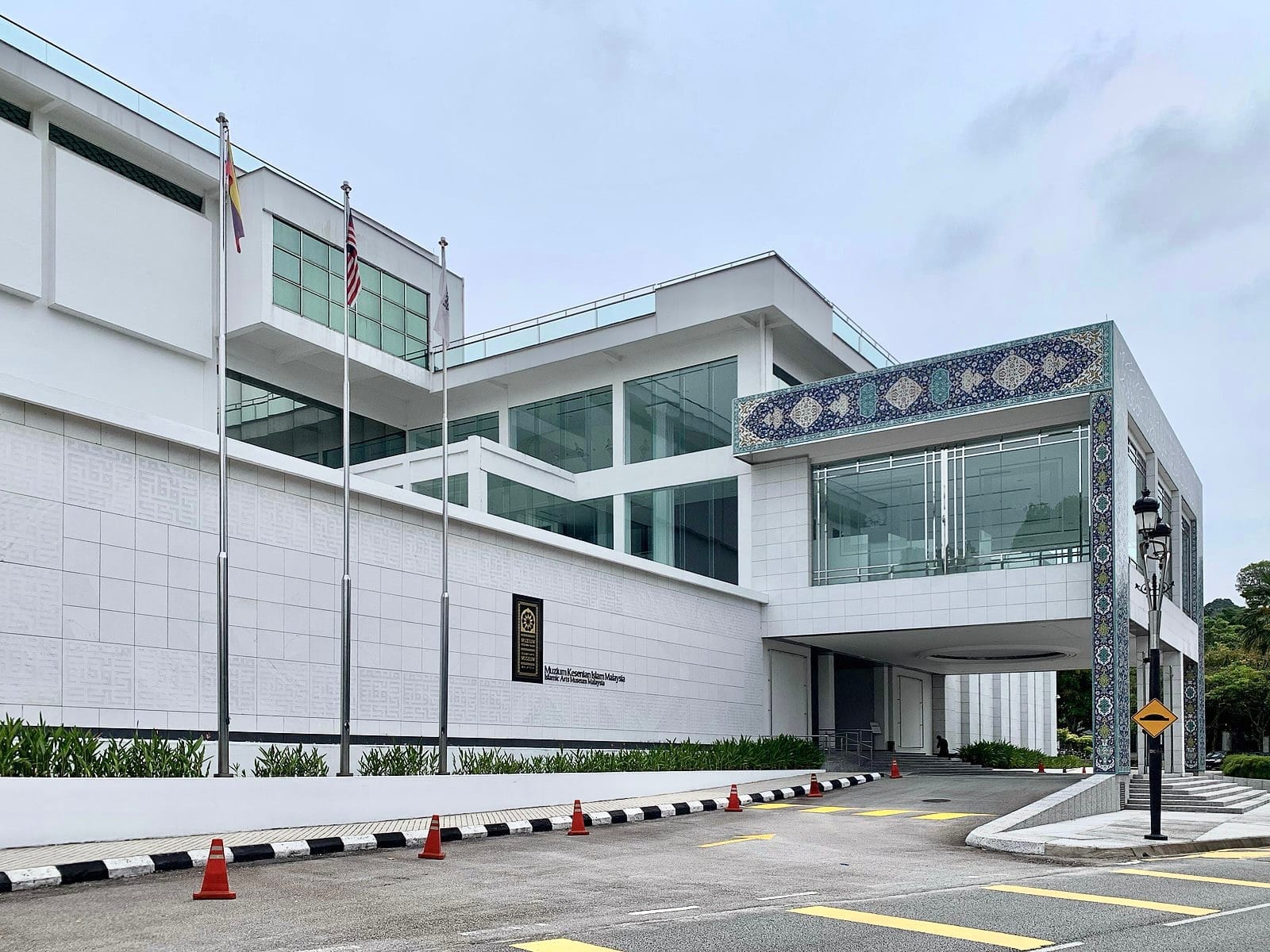 Approaching Islamic Arts Museum Malaysia, travelers are greeted by its striking architecture and distinct Islamic tilework just steps from the Lake Gardens.