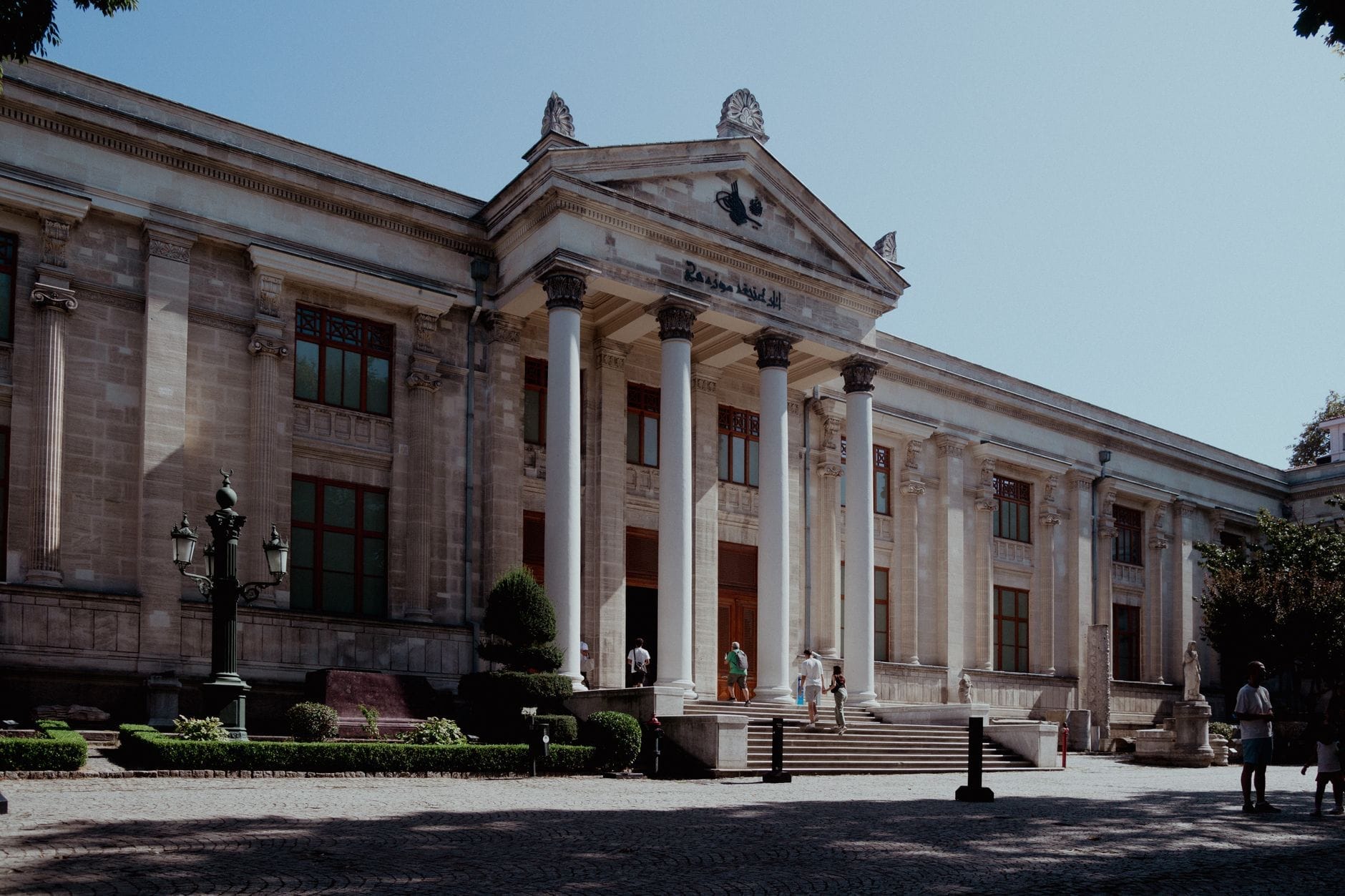 La grande facciata neoclassica del Museo Archeologico di Istanbul con alte colonne, dettagli ornati e visitatori che salgono i gradini dell'ingresso in una giornata di sole.