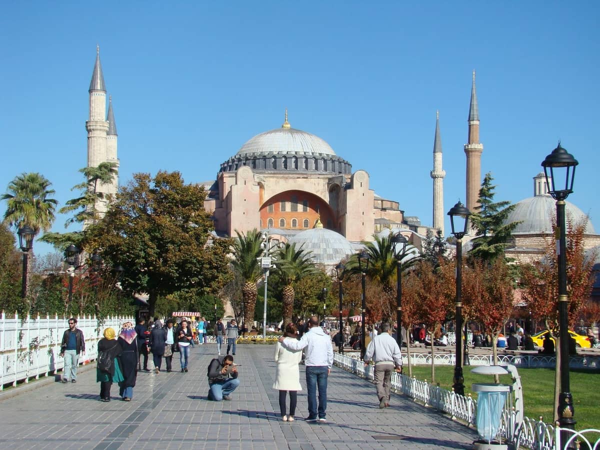 Paare und Besucher, die an einem sonnigen Tag in Istanbuls historischer Altstadt zur Hagia Sophia spazieren
