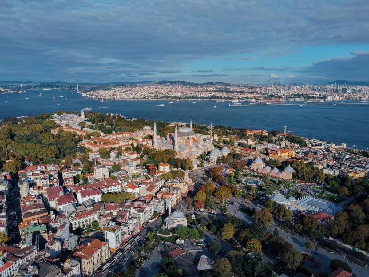 Widok z lotu ptaka na Półwysep Historyczny Stambułu z Hagia Sophia, Pałacem Topkapi i otaczającymi wodami oraz panoramą miasta w tle