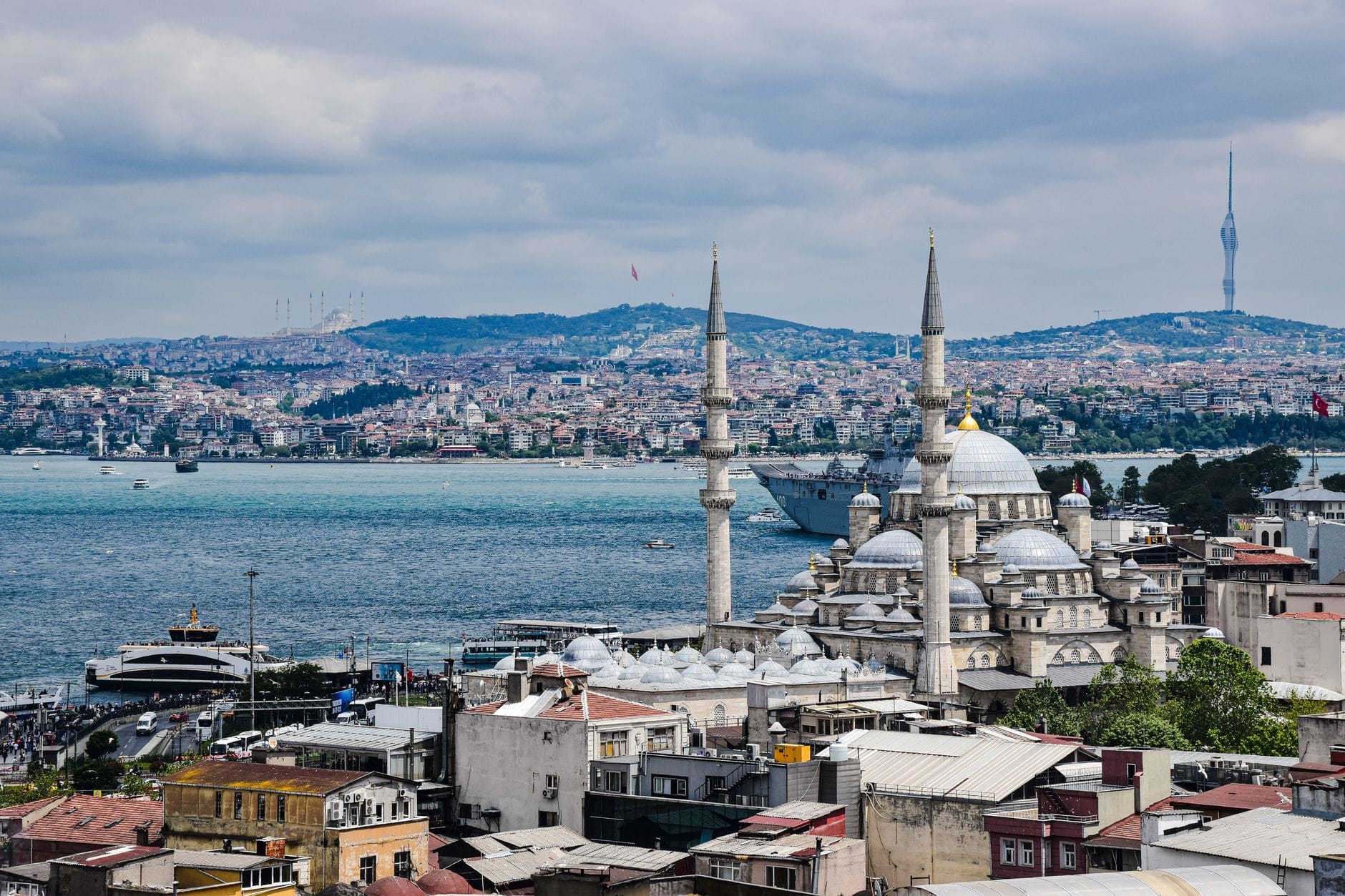 Vista panorâmica da Península Histórica de Istambul com mesquitas, o Estreito do Bósforo, prédios densamente construídos e minaretes sob um céu nublado, evocando a rica história da cidade.
