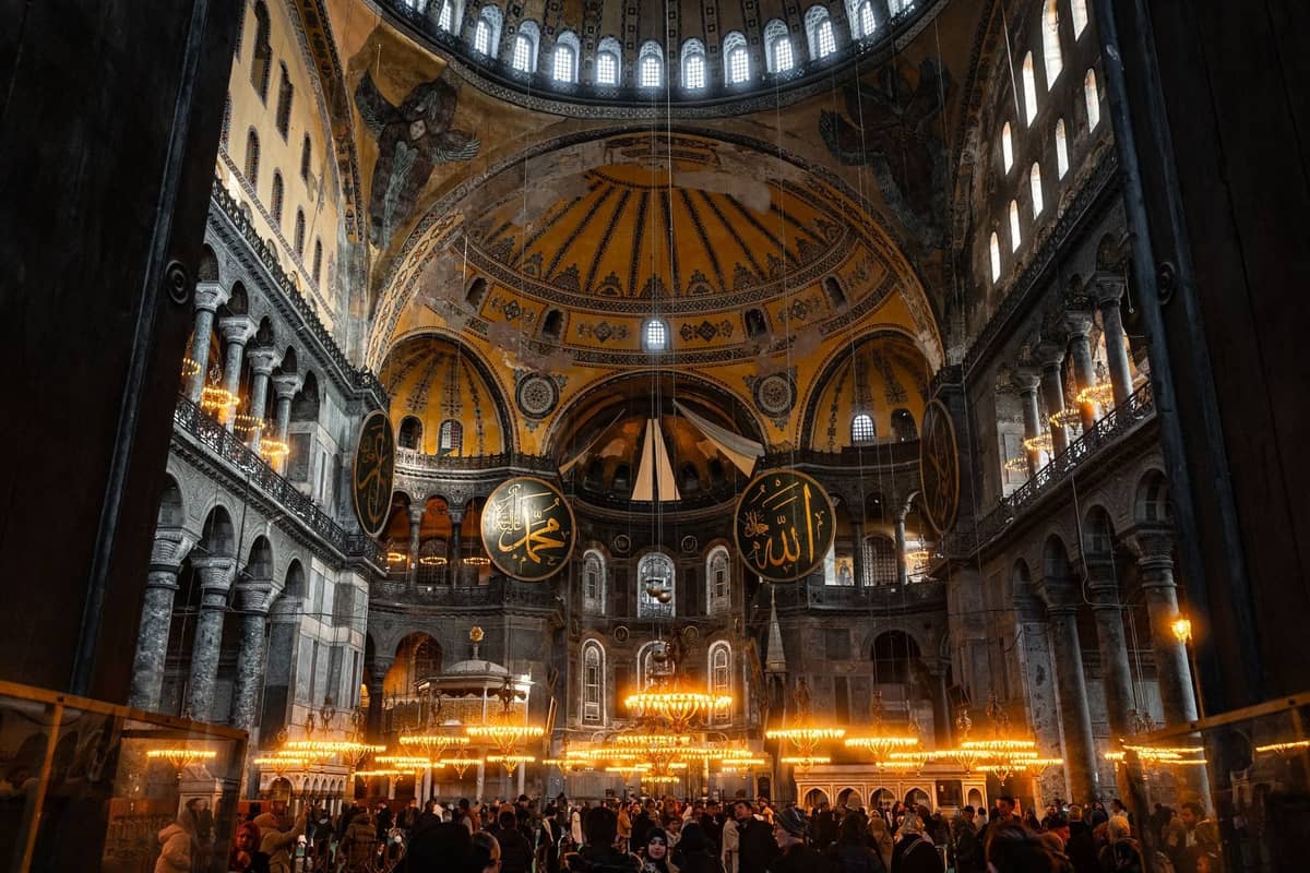 İstanbul'daki Hagia Sophia'nın ziyaretçi kalabalıkları, süslü avizeler ve görkemli kubbeli mimarisiyle geniş iç görünümü, kış turizmi için mükemmel.