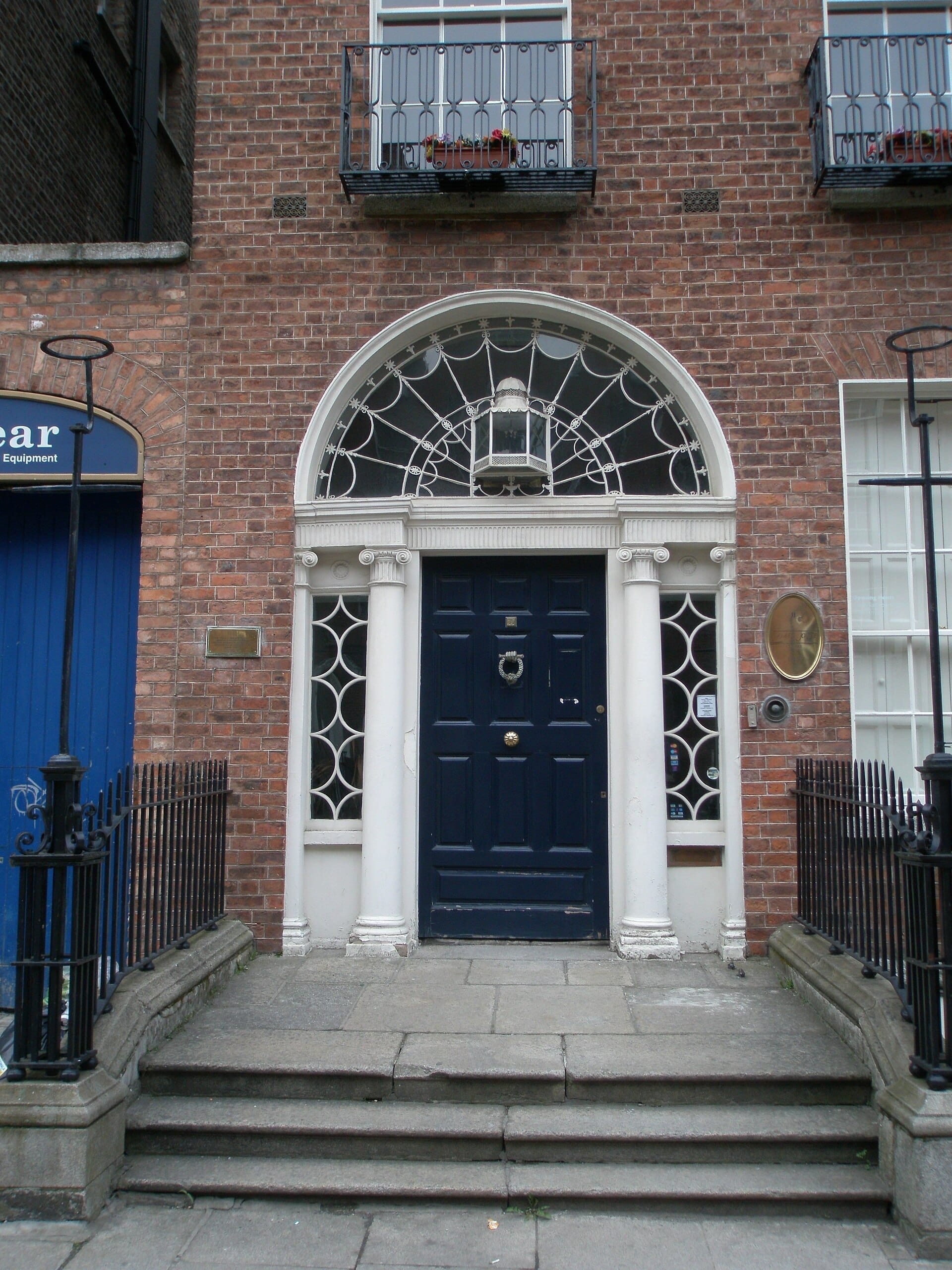 Ingresso principale del James Joyce Centre con una porta georgiana blu scuro, finestra ad arco, facciata in mattoni rossi e ringhiere in ferro su North Great George's Street.