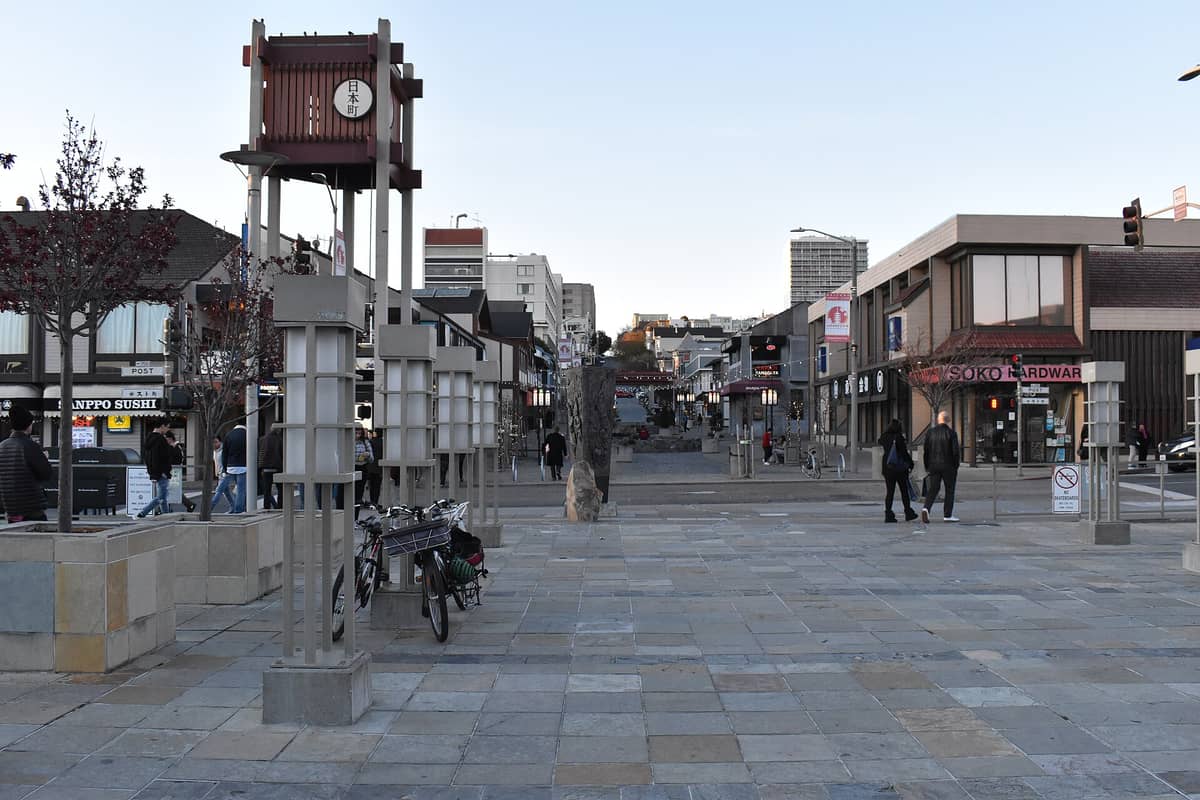 Plaza peatonal de Japantown en San Francisco, con la icónica torre de reloj de concreto de Peace Plaza, tiendas y personas caminando.
