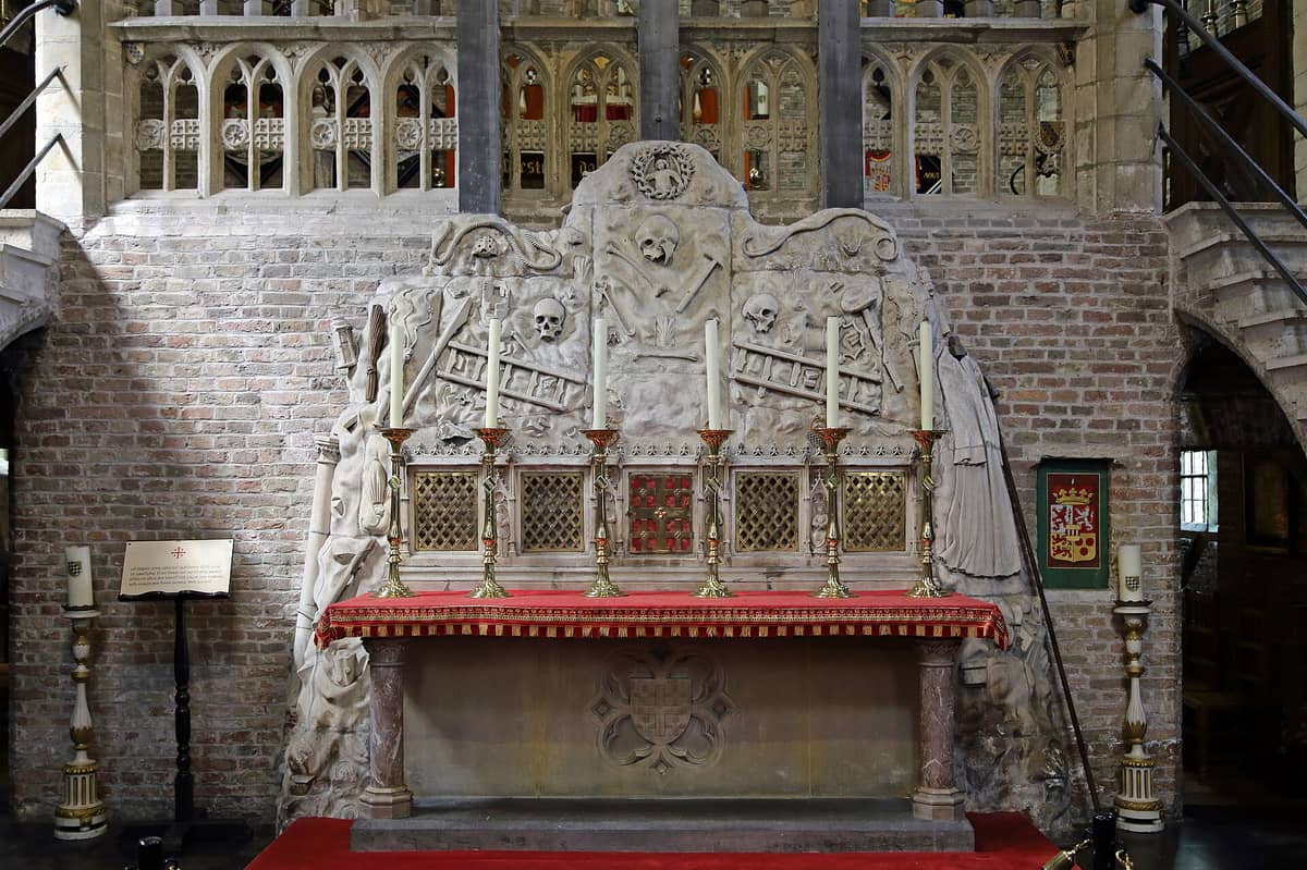 Ornate stone altar with skull motifs and candles inside the Jeruzalemkerk, the Jerusalem Church in Bruges, Belgium.