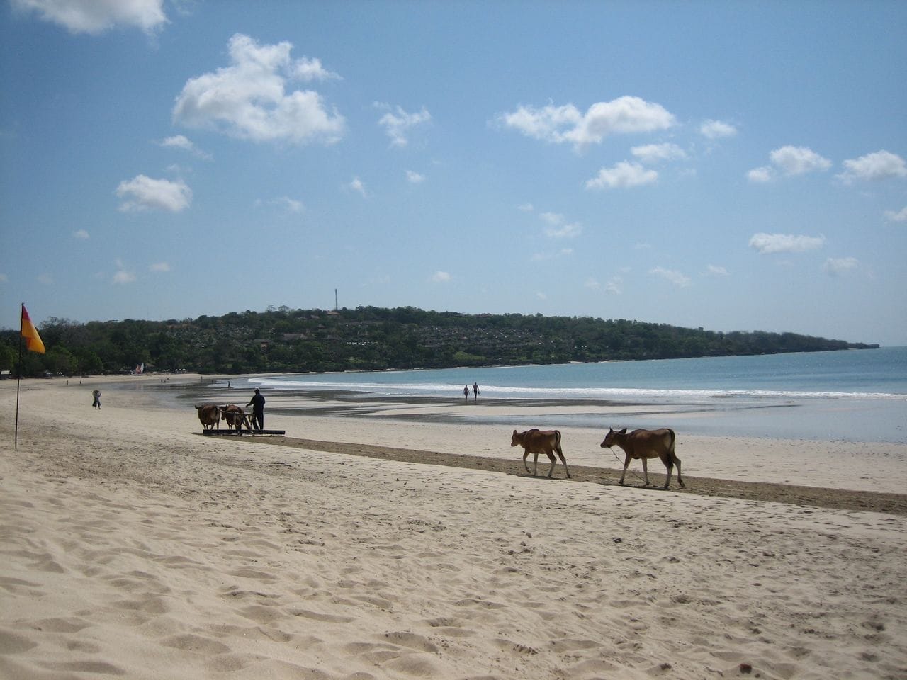 L'arco di sabbia dorata della spiaggia di Jimbaran Bay con l'atmosfera tranquilla del villaggio di pescatori