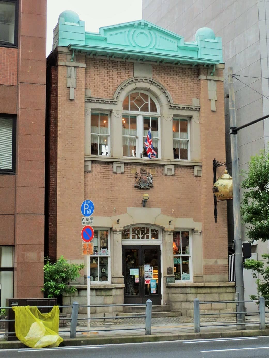 Front view of the Kitahama Retro Building, a two-story brick structure with arched windows and a British flag above the entrance.