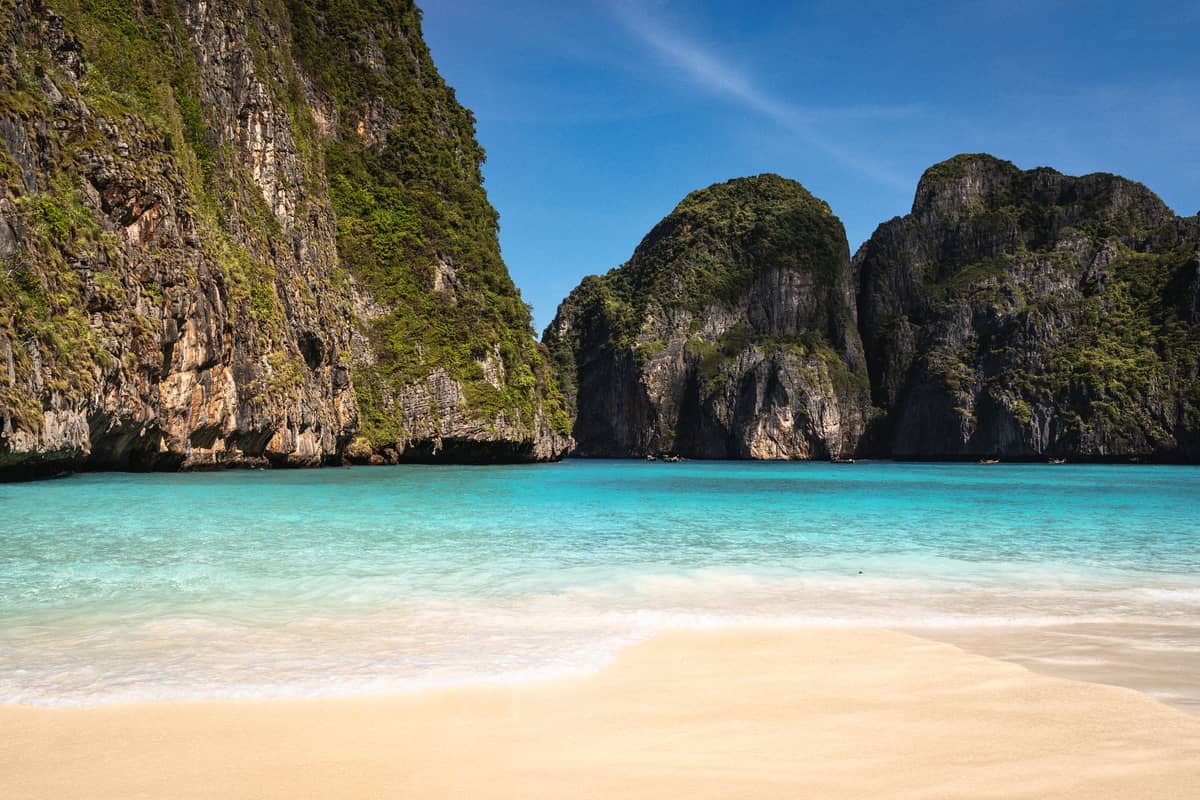 Grande plage de sable avec des eaux turquoise et des falaises calcaires spectaculaires à Maya Bay, Koh Phi Phi Leh, Krabi, Thaïlande.