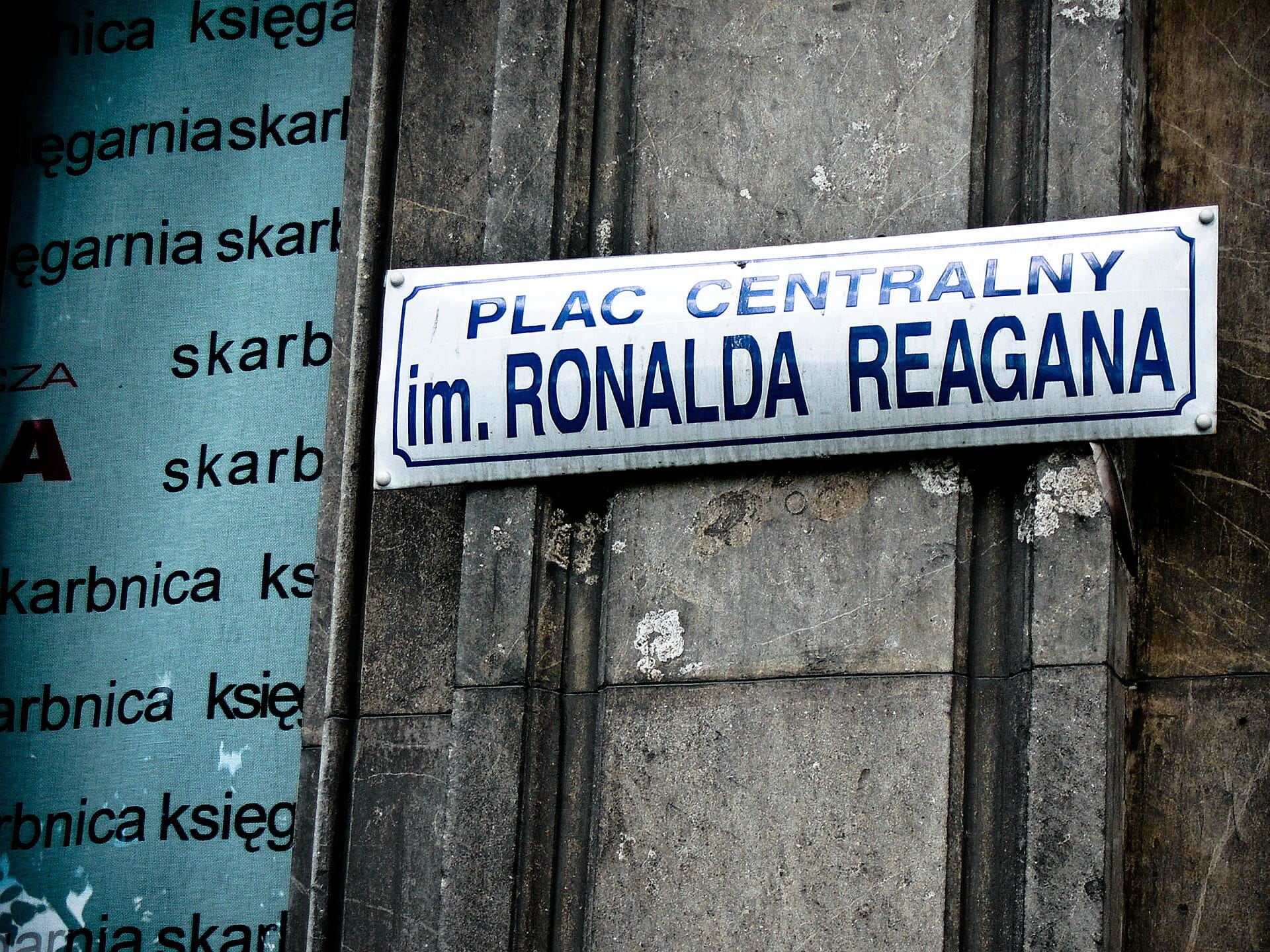 ภาพระยะใกล้ของป้ายถนน Plac Centralny im. Ronalda Reagana บนกำแพงหินใน Nowa Huta เมือง Kraków