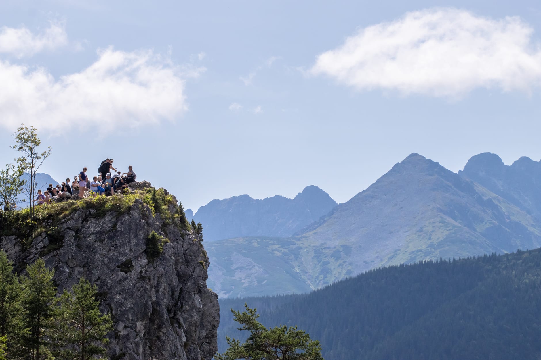 ผู้คนอยู่บนโขดหินชมวิวพาโนรามาภูเขา Tatra และผืนป่าใกล้ Zakopane ในวันที่อากาศแจ่มใส