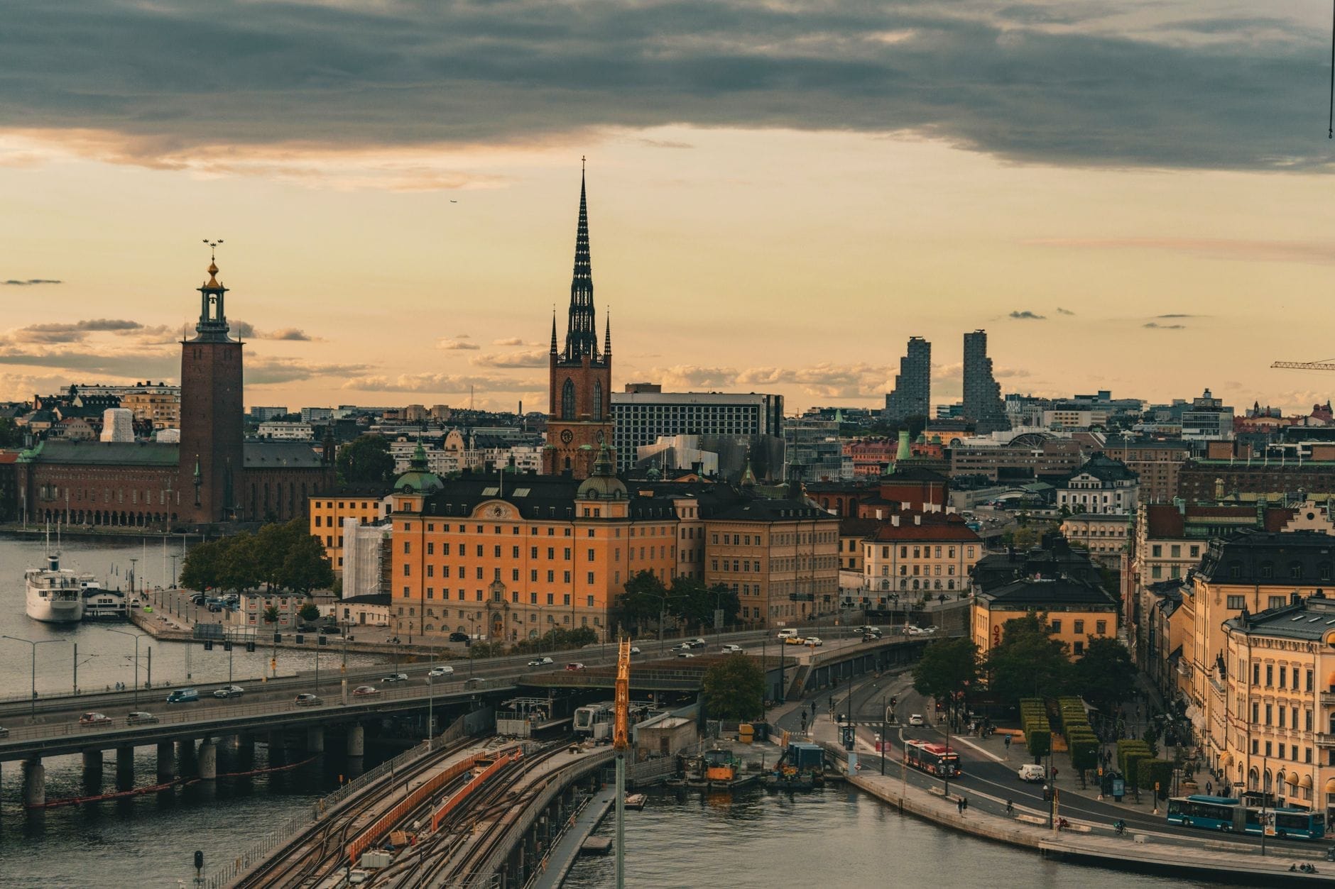 วิวพาโนรามาของ Kungsholmen ในสตอกโฮล์ม โดดเด่นด้วย Stockholm City Hall อาคารประวัติศาสตร์ สะพาน และทางน้ำ ใต้ท้องฟ้ายามเย็นที่มีเมฆปกคลุม