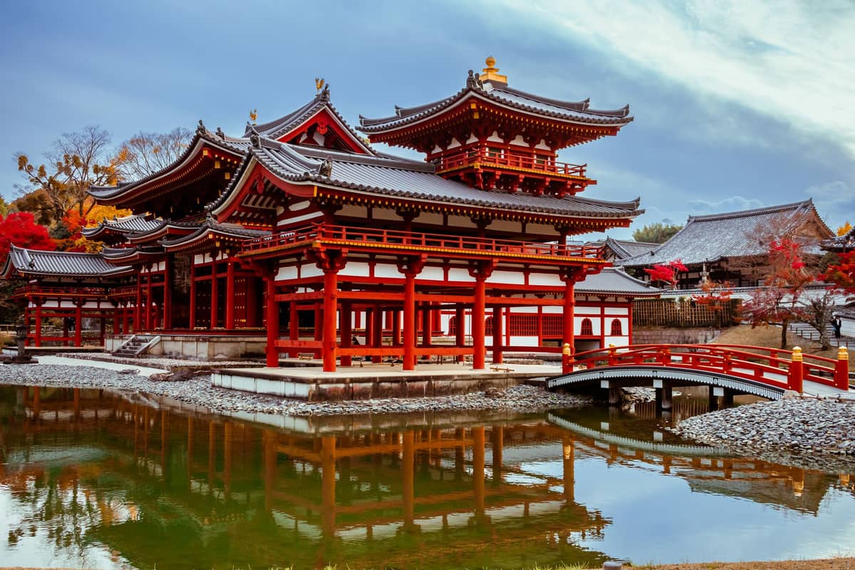 Byodo-in Temple in Uji, Kyoto, a striking red historic building with ornate rooftops and a scenic pond reflecting the structure.