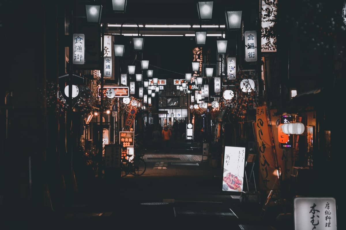 Kyoto night street lined with glowing lanterns and bar signs, creating a lively and inviting nightlife atmosphere.