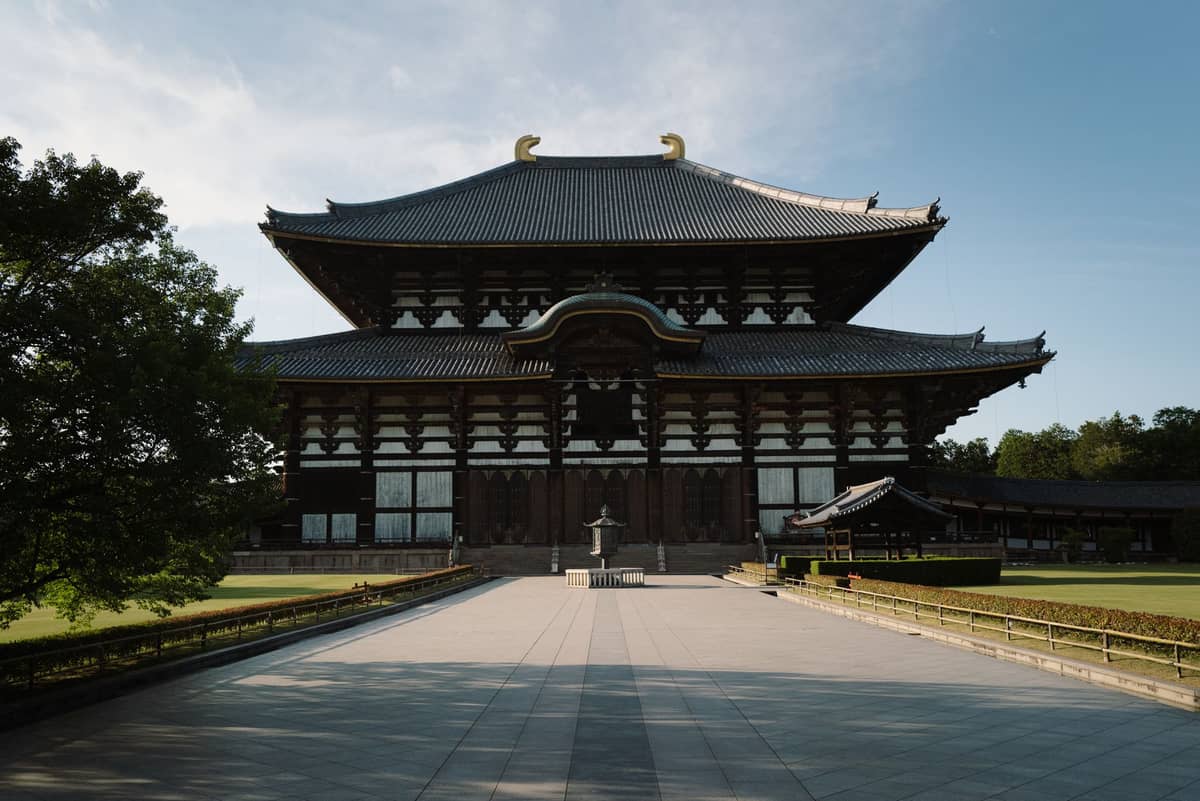 Wide view of Todai-ji Temple’s Great Buddha Hall in Nara on a clear day, featuring the grand wooden façade and open plaza in front.
