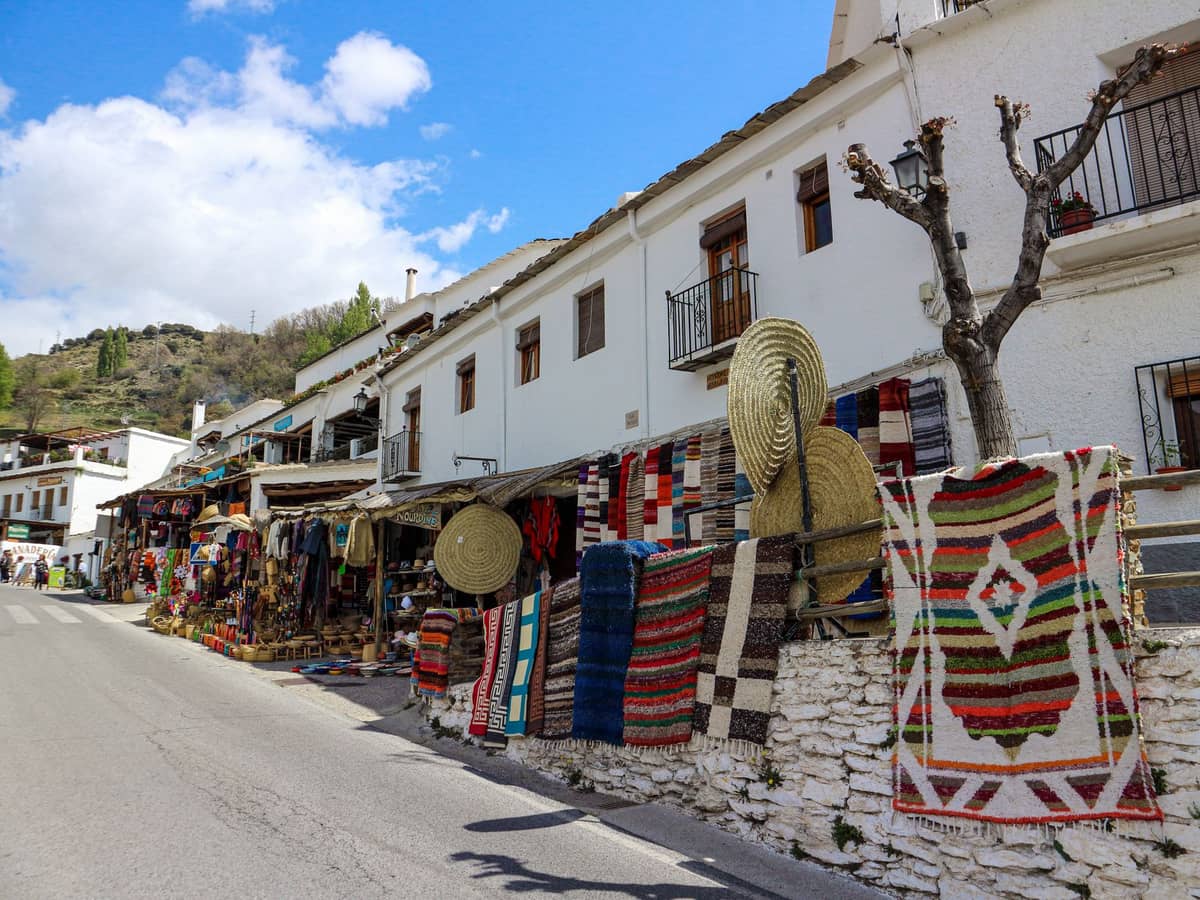 ถนนใน Pampaneira หมู่บ้าน Las Alpujarras บ้านผนังขาวปูน หญ้าสีสดวางขายริมกำแพงกลางแดด