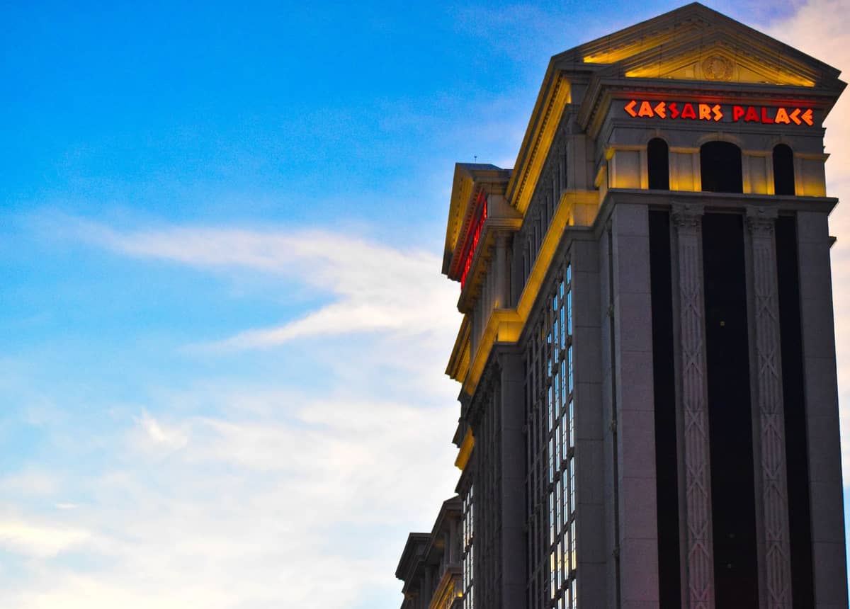 Der Hotelturm des Caesars Palace mit seinem leuchtenden Neonschild in der Abenddämmerung in Las Vegas