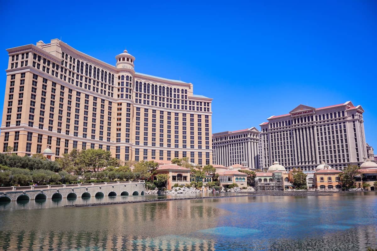 Tagesansicht über die Bellagio-Fontänen zum Bellagio-Hotel, mit dem Caesars Palace in der Nähe unter einem klaren blauen Himmel.