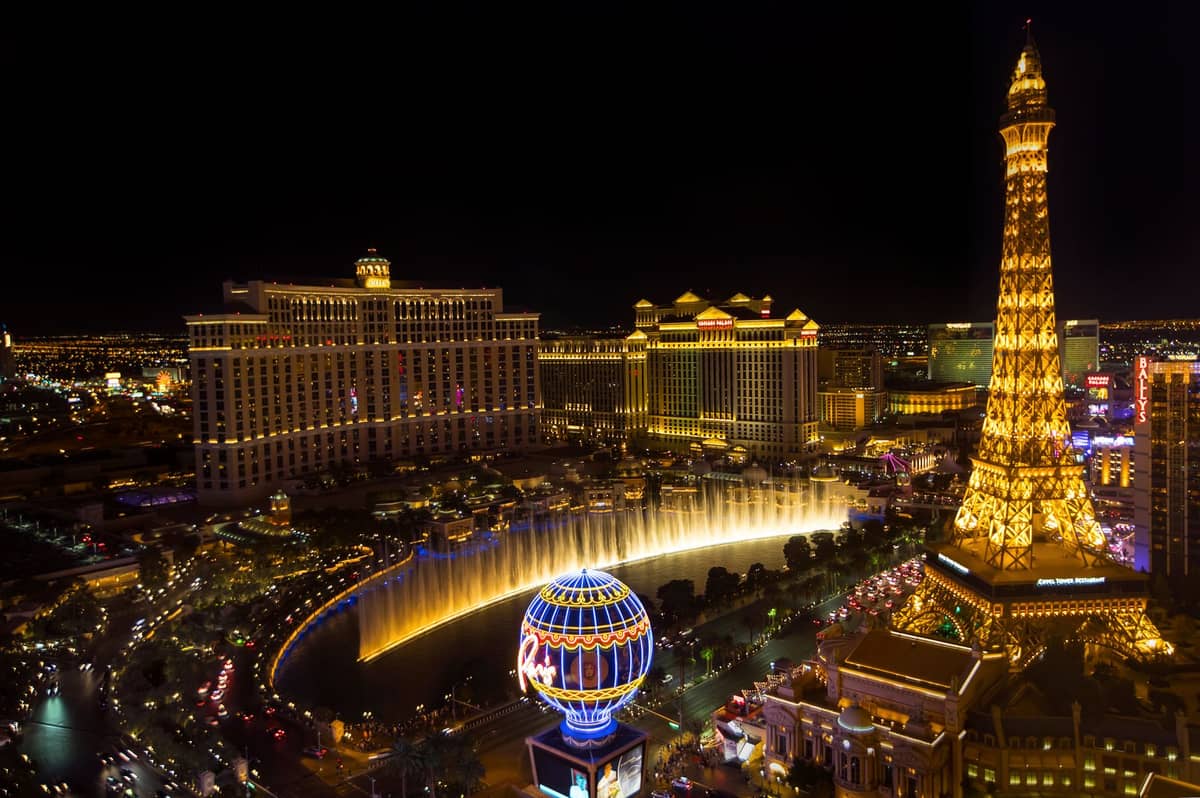 Vista nocturna del Strip de Las Vegas con las fuentes del Bellagio, la Torre Eiffel del Paris Las Vegas y las luces de los resorts, mostrando los íconos románticos de la ciudad.