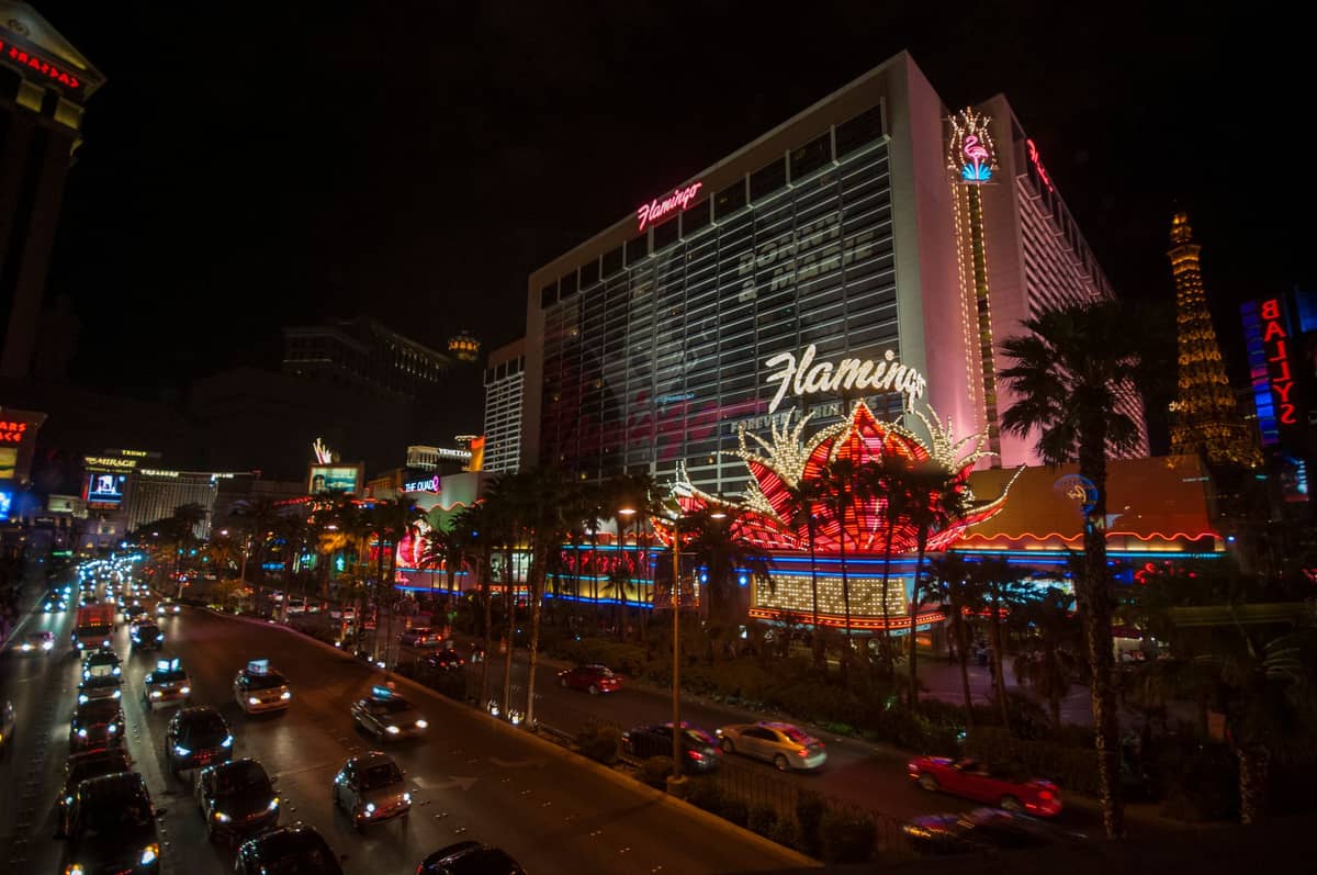 วิวยามค่ำคืนของโรงแรมและคาสิโน Flamingo Las Vegas พร้อมไฟนีออนและรถยนต์คับคั่งบน Las Vegas Strip