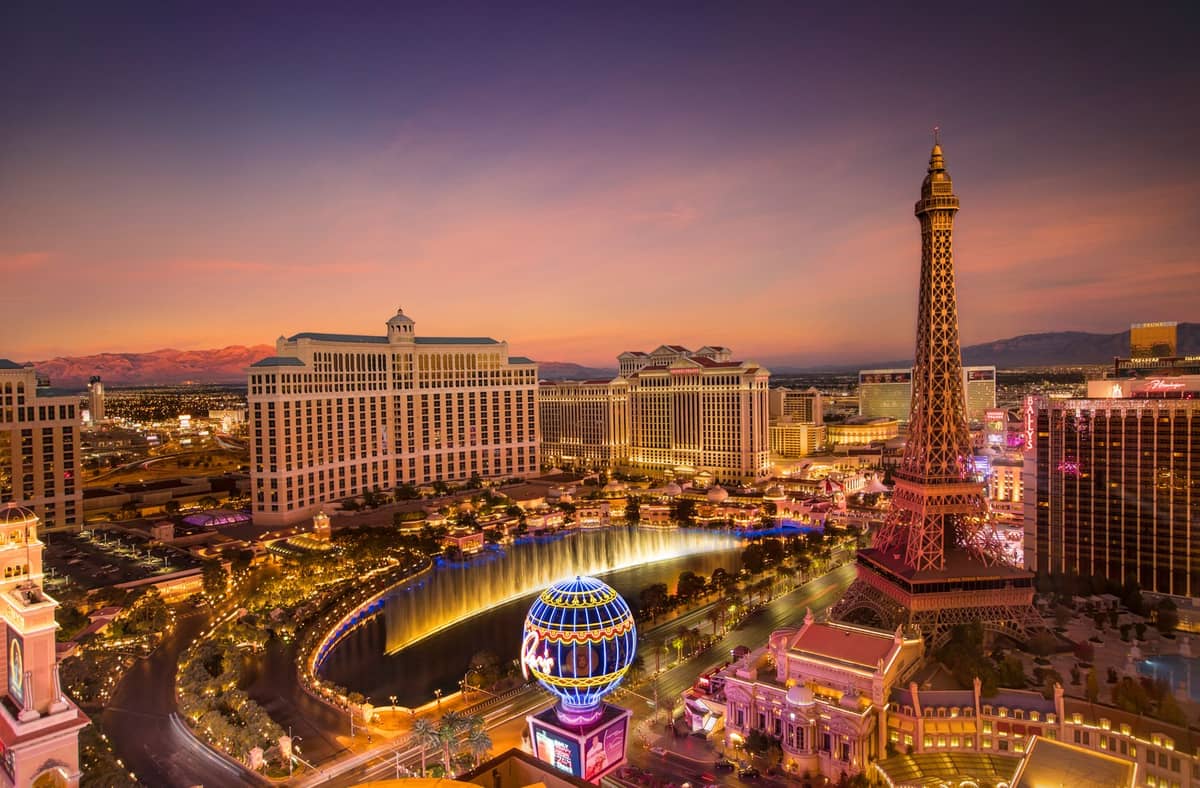 ภาพทางอากาศของ Las Vegas Strip ยามพระอาทิตย์ตกดิน พร้อมการแสดงน้ำพุ Bellagio Fountains โรงแรม Bellagio และจำลอง Eiffel Tower ที่ Paris Las Vegas