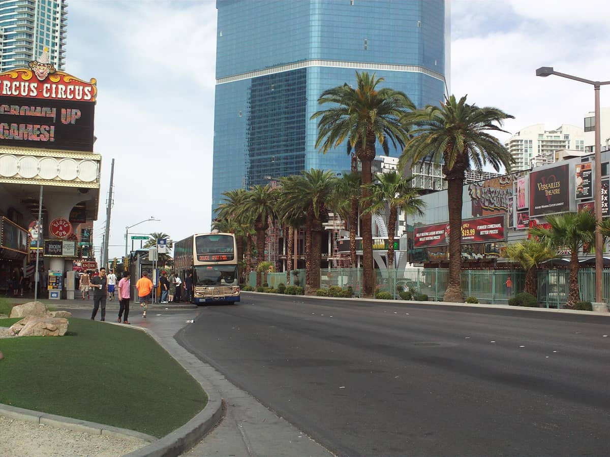 รถบัสสองชั้นรับผู้โดยสารบน Las Vegas Strip ใกล้กับ Circus Circus โดยมีต้นปาล์มและคาสิโนเป็นฉากหลัง