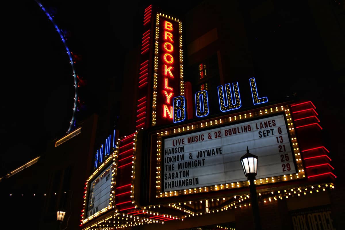 Vista nocturna del marquesino de Brooklyn Bowl iluminado con nombres de espectáculos, destacando un popular lugar de entretenimiento en Las Vegas fuera de Cirque.