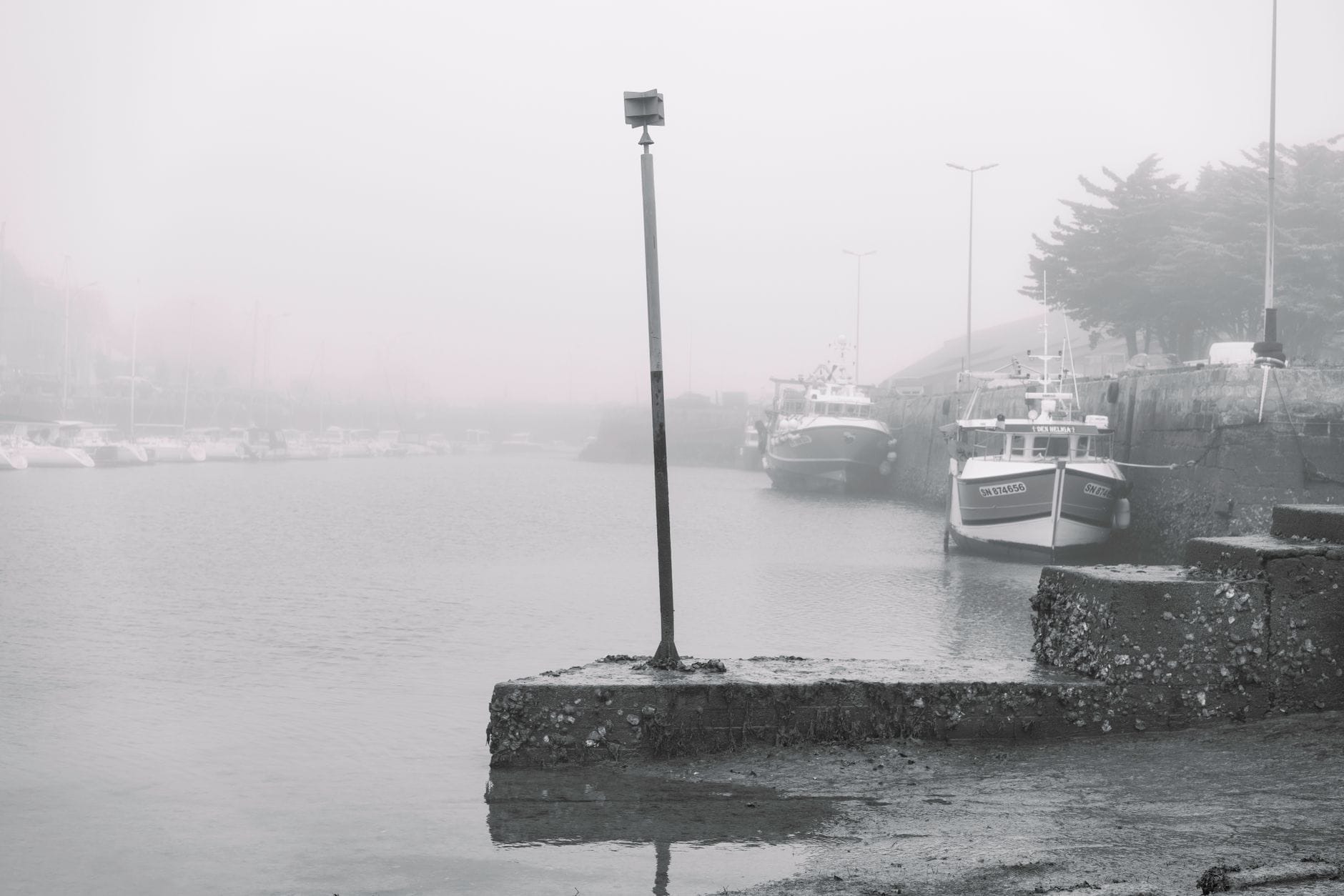 Le Havre limanında rıhtım boyunca teknelerin bulunduğu sisli bir liman sahnesi; yayık ışık ve sis, empresyonist bir atmosfer yaratıyor.