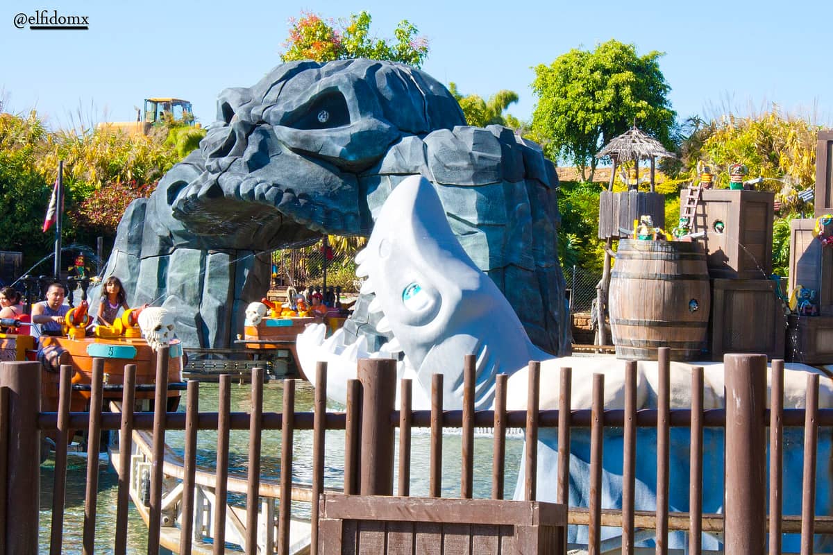 Interaktive Wasserfahrt im LEGOLAND California mit Booten, thematischen Piraten- und Monsterskulpturen und Familien, die die farbenfrohe Außenattraktion genießen.
