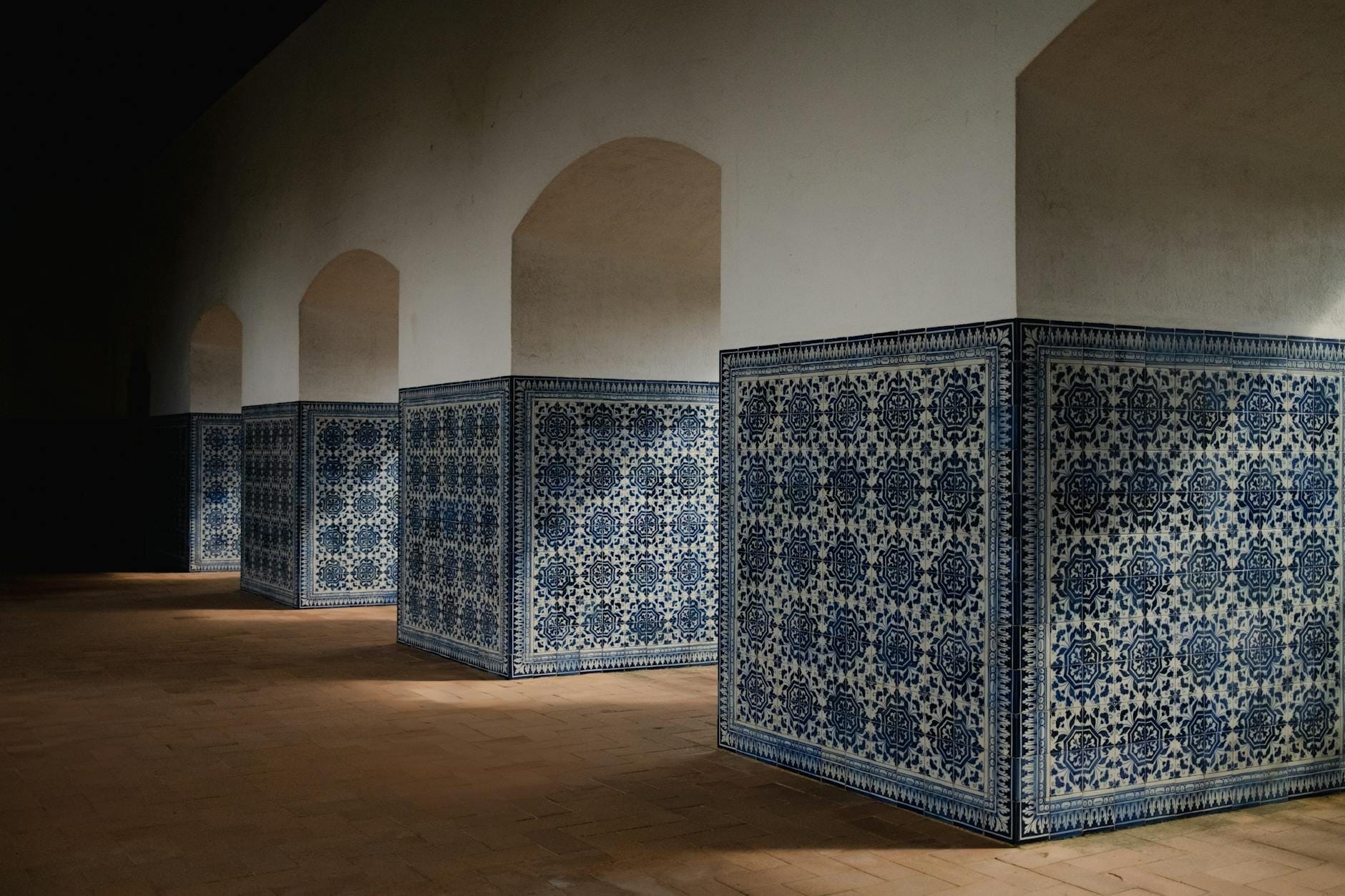 Intérieur d'un vieux bâtiment à Lisbonne avec des colonnes recouvertes d'azulejos portugais traditionnels bleu et blanc, faiblement éclairé et rappelant un musée.