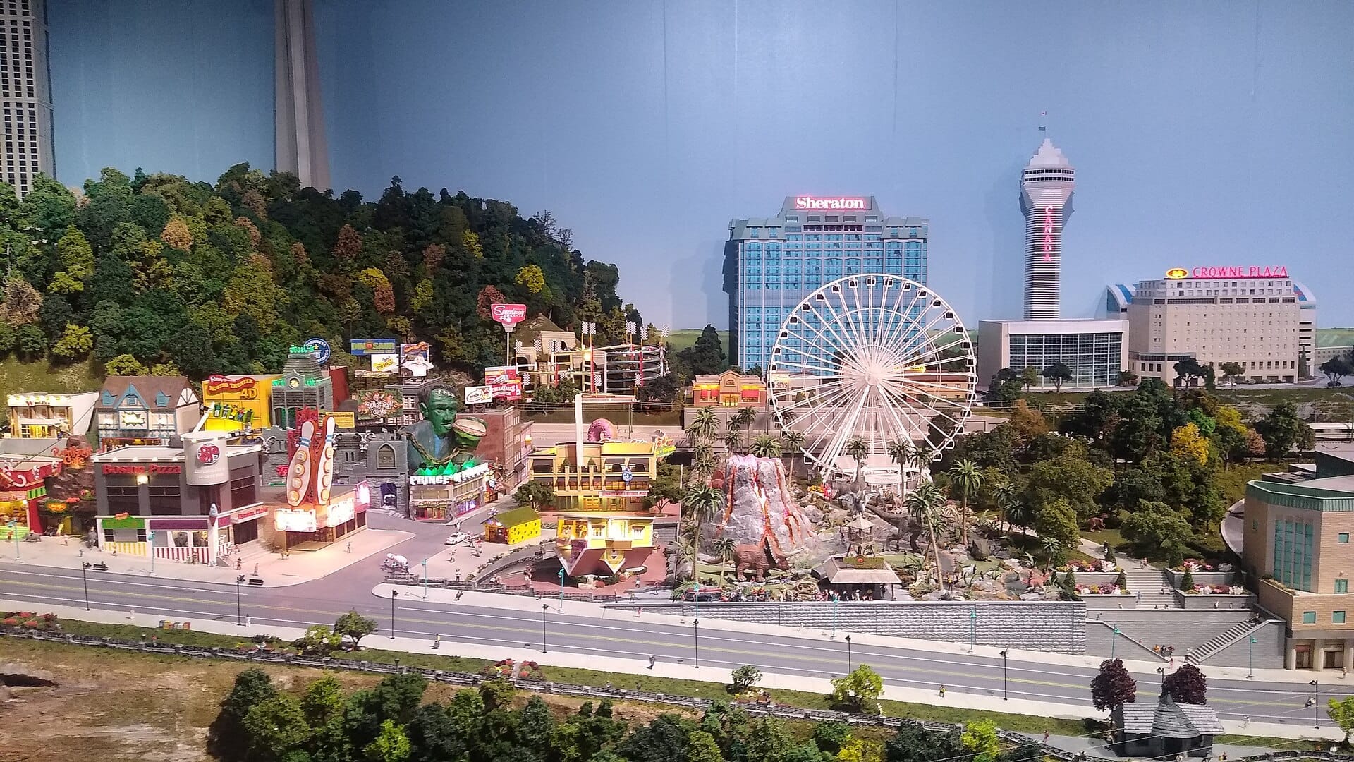 แบบจำลองย่อส่วนละเอียดของ Little Canada Toronto ที่มีชิงช้าสวรรค์ขนาดใหญ่ สถานที่ท่องเที่ยวสีสันสดใส โรงแรมในเมือง และต้นไม้จำลองขนาดเล็กที่เขียวชอุ่มภายใต้แสงไฟสว่างไสว