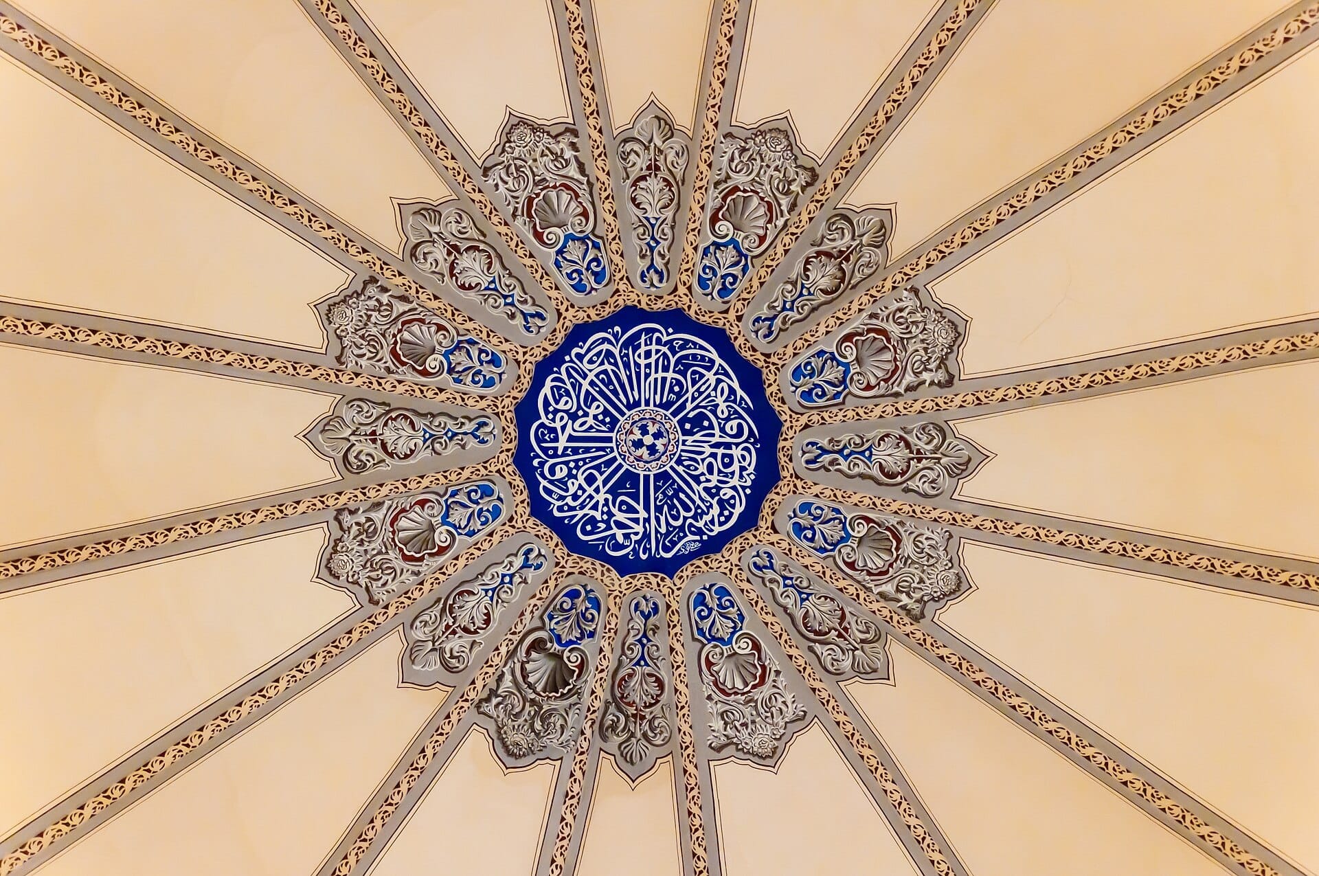 Intricati motivi geometrici e floreali sul soffitto della cupola centrale della moschea Little Hagia Sophia a Istanbul, con colori blu, bianco e beige.