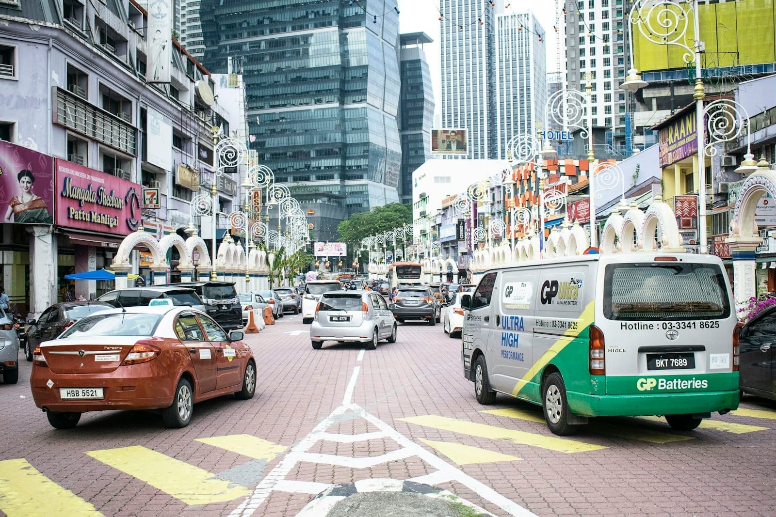 Vibrant streets of Little India Brickfields in Kuala Lumpur, with colorful shops, flower garlands, and Tamil temple architecture.