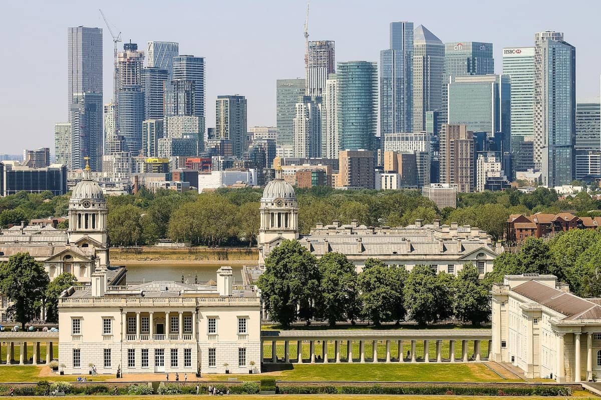 Vista do Old Royal Naval College e da Queen's House com o rio Tâmisa e o horizonte de Canary Wharf em Londres.