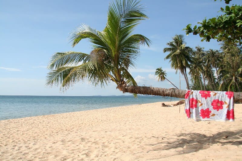 Spiaggia dorata di Long Beach a Phu Quoc al tramonto, con acque calme rivolte a ovest e palme lungo la riva
