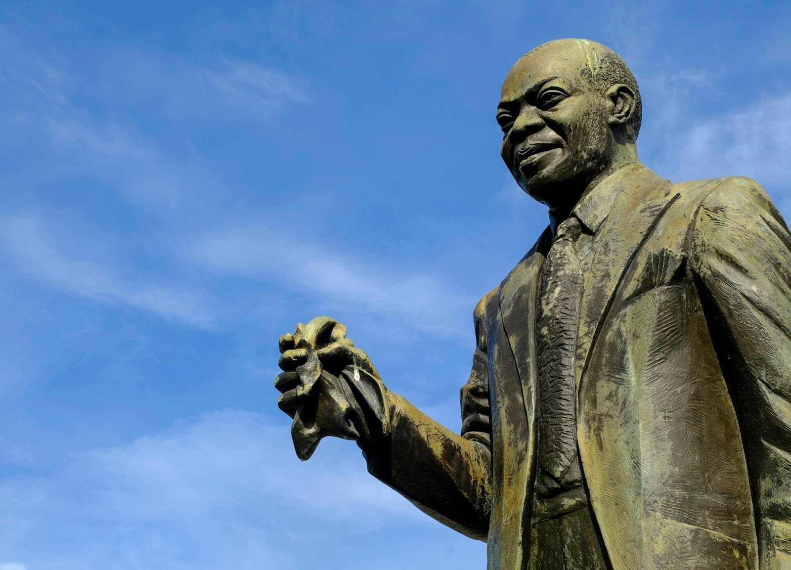 Statua in bronzo di Louis Armstrong nel Louis Armstrong Park, New Orleans, su uno sfondo di cielo azzurro brillante.