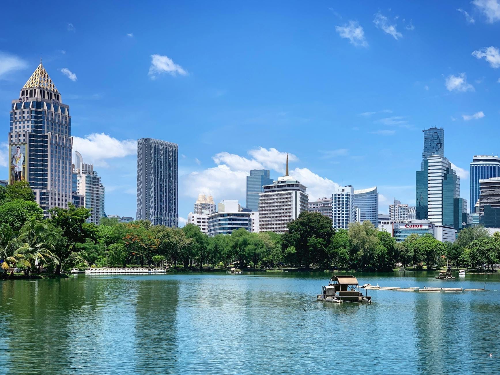 Lumphini Park a Bangkok con lago, barchetta e vista sullo skyline