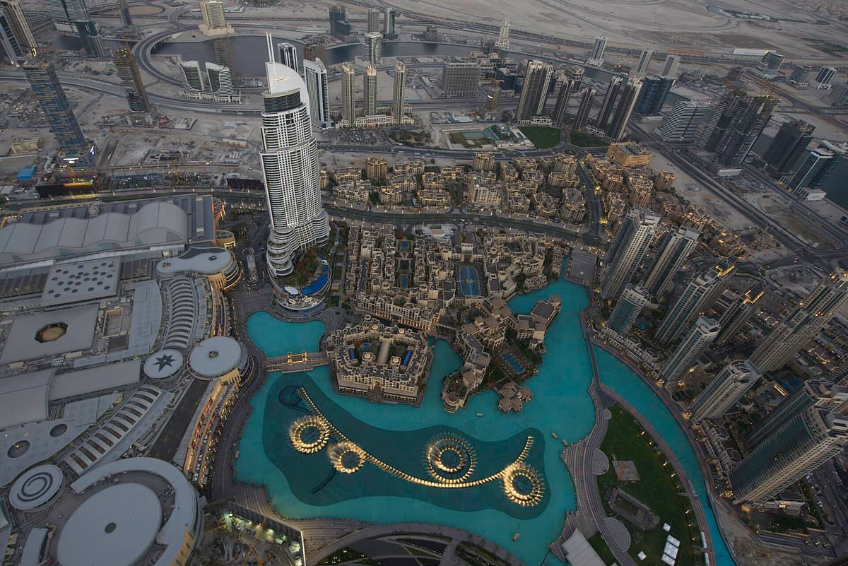 Ein atemberaubender Luftblick vom Burj Khalifa mit der Dubai Fountain, dem Hotel Address Downtown und den umliegenden Wolkenkratzern in der Abenddämmerung.