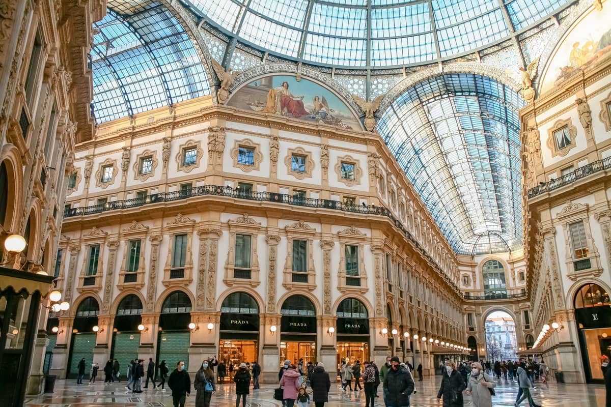 Eleganckie wnętrze ze szklanym dachem Galleria Vittorio Emanuele II w Mediolanie z przechodniami i wspaniałymi detalami architektonicznymi.