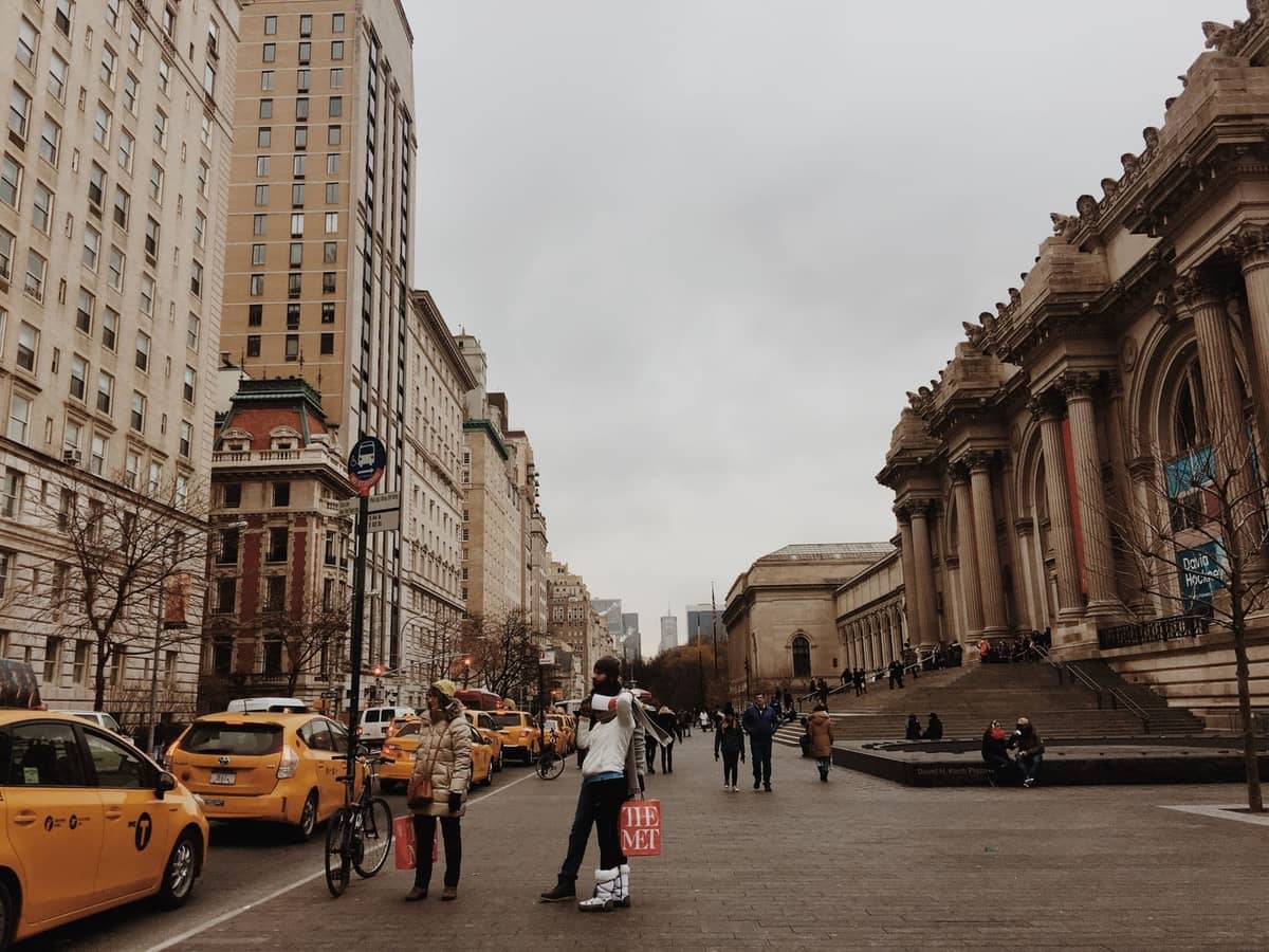 Straßenansicht von New York City mit gelben Taxis und dem Metropolitan Museum of Art an einem bewölkten Tag.