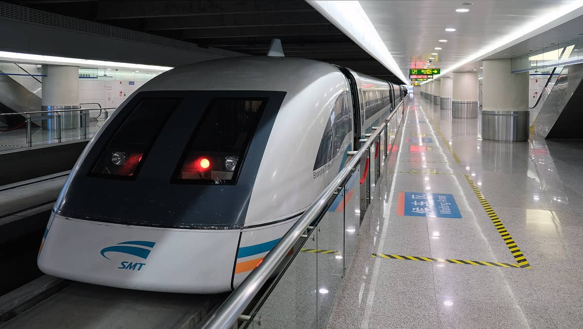 Shanghai Maglev Train wartet auf dem Bahnsteig eines modernen Bahnhofs, mit heller Beleuchtung und einem eleganten Triebwagen.
