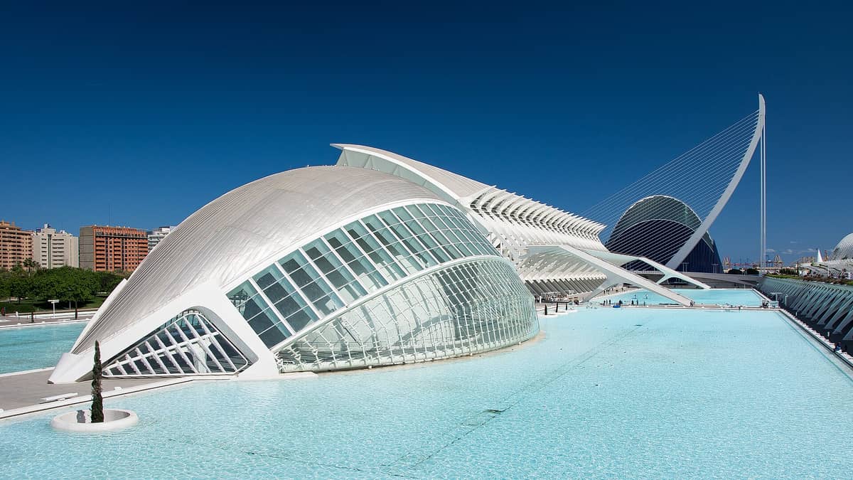 Berrak bir günde turkuaz yansıma havuzlarının üzerinde L'Hemisfèric, Museu de les Ciències ve L'Assut de l'Or Köprüsü ile Valencia'nın Ciudad de las Artes y las Ciencias'ının panoramik görünümü.