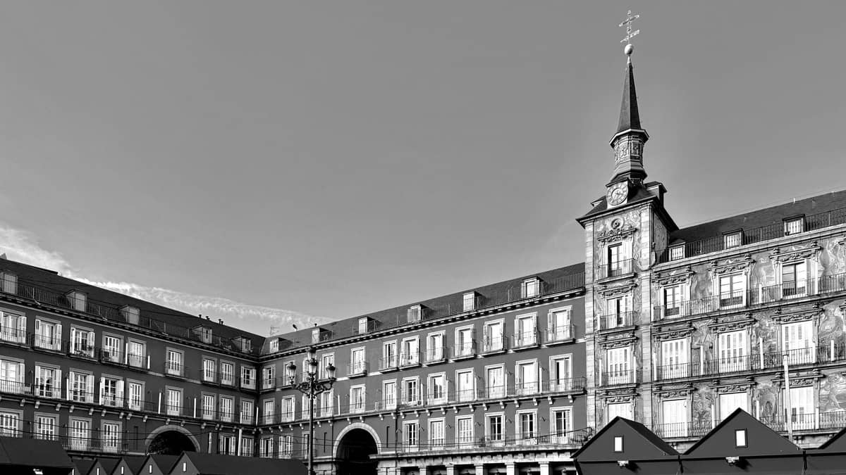 Schwarz-Weiß-Ansicht der Plaza Mayor in Madrid mit aufgebauten Weihnachtsmarktständen auf dem Platz.