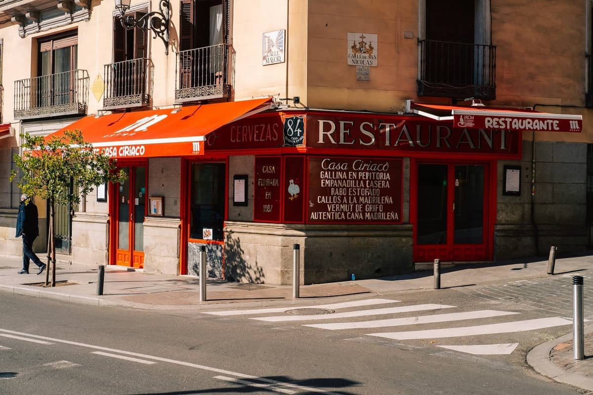 Madrid'de kırmızı tenteli ve dışarıda menü tahtası olan uygun fiyatlı bir restoranın sokak görünümü, menú del día denemek için ideal.