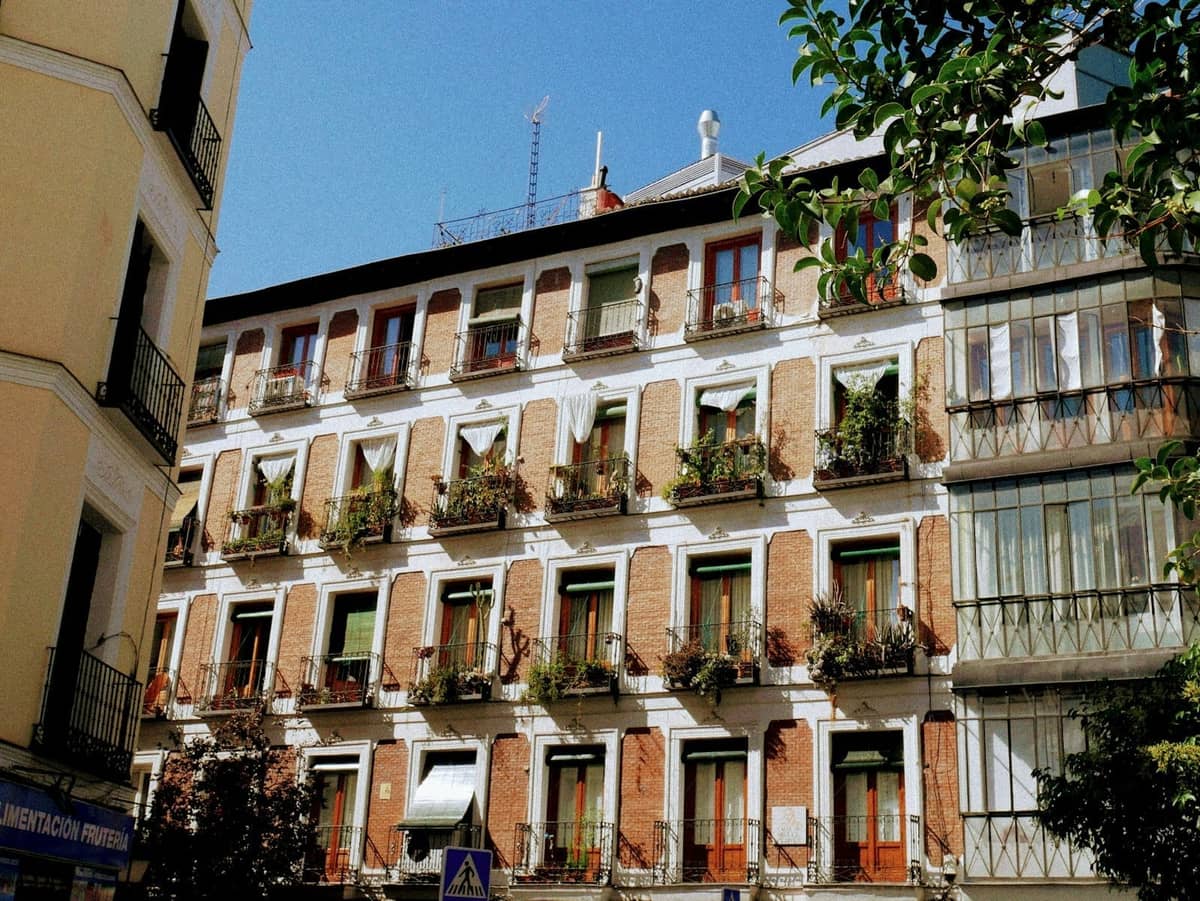 Madrid'de birçok balkon ve bitkiyle süslenmiş geleneksel apartman binası, merkezi bir mahallede uygun fiyatlı yerel konaklama seçeneklerini sergiliyor.
