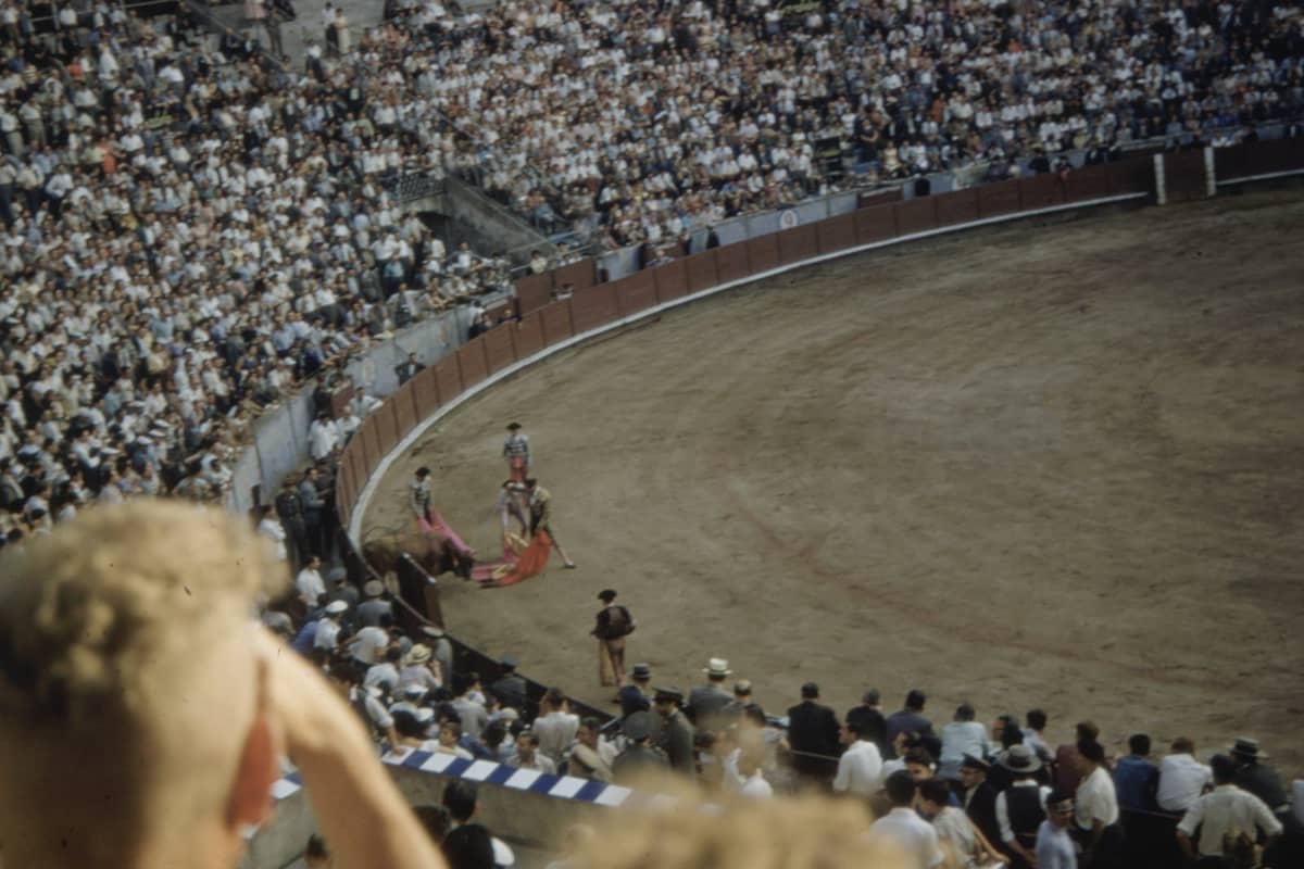 Blick auf eine überfüllte Stierkampfarena während eines Stierkampfes, mit Matadoren und Zuschauern, die die Arena Las Ventas füllen.
