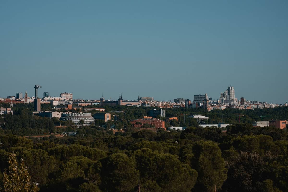 Weiter Stadtblick auf Madrid mit grünem Park und Skyline, mit verschiedenen Vierteln und Wahrzeichen der Stadt.